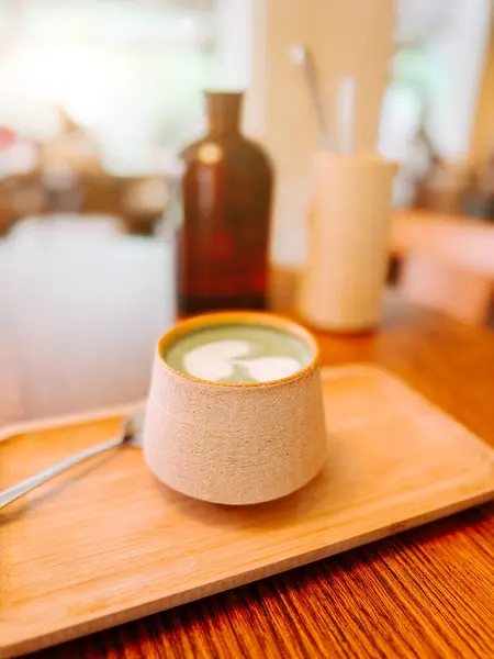 Sıcak bir kafede, ahşap bir tepside seramik bir bardakta sunulan nefis kibrit suyu.