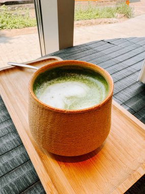 Güneşli bir öğleden sonra bir kafede seramik bir kasede servis edilen rahatlatıcı kibrit içeceği.