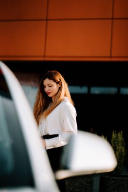 Modern bir kentsel alanda bir şarj istasyonunda çalışan bir kadın.