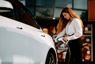 Kadın elektrik istasyonunda gündüz saatlerinde elektrik yüklüyor.