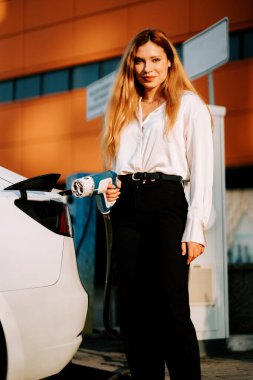 Kızıl saçlı genç bir kadın alışveriş merkezinde elektrikli araç kullanıyor.