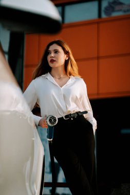 Kızıl saçlı genç bir kadın öğleden sonra alışveriş merkezinde elektrikli araç kullanıyor.