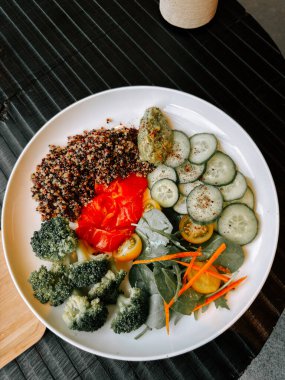 Şık bir tabakta taze sebzeli sağlıklı kinoa salatası.