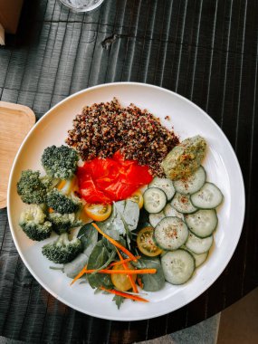 Sağlıklı kinoa salatası, taze sebzeler ve canlı renkler bir kasede servis edilir.