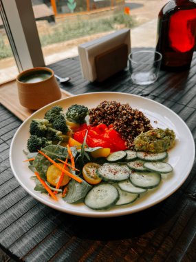 Sıcak bir ortamda sunulan taze sebzeli sağlıklı kinoa salatası.