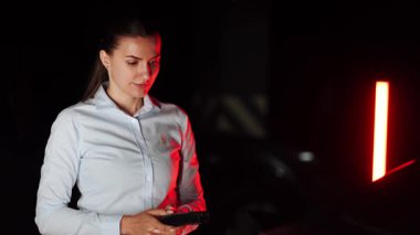 Kadın yeraltı otoparkında etkili bir şekilde elektrikli araba şarj ediyor.
