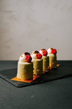 Tahta tabakta ahudududulu yeşil hamur tatlısı sergilenen lezzetli bir tatlı sergisi.