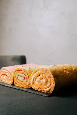 Kekler koyu bir yüzey üzerinde canlı katmanlar ve dokular sergilenir.