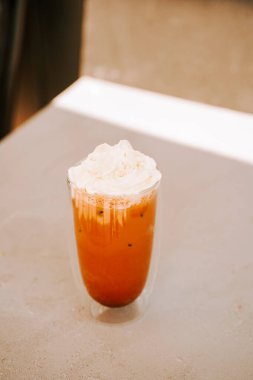 Masanın üstündeki kremalı buzlu içecek. Pencereden süzülen sıcak güneş ışığı.