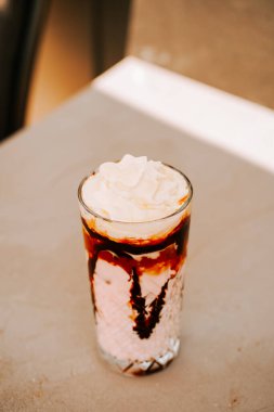 Çırpılmış krema ve çikolata şurubuyla kaplanmış lezzetli tatlı içeceği güneşli bir günde servis edilir.