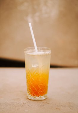 Serinletici katmanlı içecek güneşli bir açık hava ortamında şık bir bardakta servis edilir.