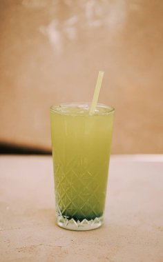 Açık havada sıcak bir öğleden sonra kristal bardakta servis edilen ferahlatıcı yeşil içecek.