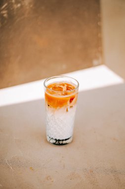 Güneşli bir yüzeyde buzlu bir bardakta servis edilen ferahlatıcı içecek.