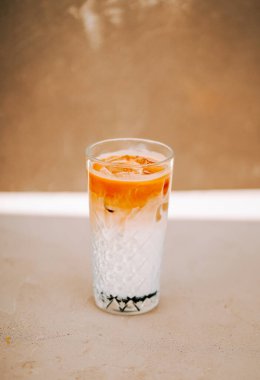 Berrak bir bardakta servis edilen, renkli katmanlı bir içecek.