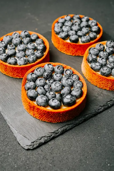 Yaban mersinli turtalar, parlak bir mutfak ortamında siyah bir tabağa dizilmiş.