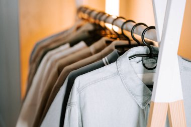 Modern bir butik ortamında askılarda sergilenen şık kıyafet koleksiyonu