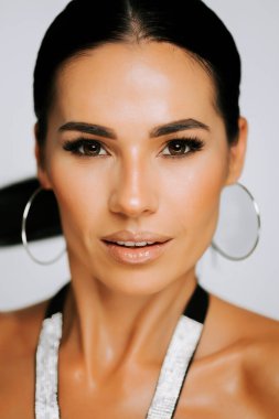 Moda çekimi sırasında basit stüdyo ortamında kendine güveni olan şık bir model poz verir.