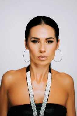 Zarif model, bir stüdyoda moda ve güzellik gösterisine özgüvenle poz veriyor.