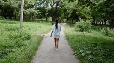 Huzurlu bir yolda yürürken huzur dolu bir parkta yeşilliklerle çevrili.