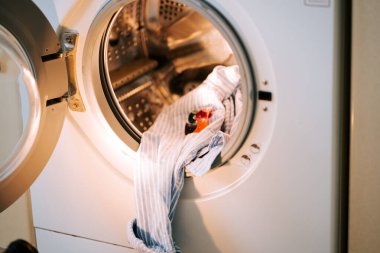 Kirli çamaşırları çamaşır deterjanıyla yıkamak modern bir çamaşır makinesinde.