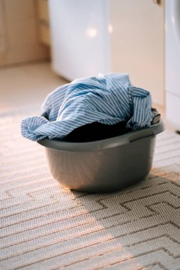 Çamaşır odasında çamaşır makinesini kullanarak kirli çamaşırları yıkamak.