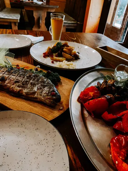 Manzaralı bakış açısı, göl kenarındaki bir sehpa tarafından çerçevelenmiş doğal bir manzarayı gösteriyor.