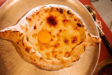 Lezzetli Adjarian Khachapuri ortasında mükemmel bir pişmiş yumurta ile servis edilir.