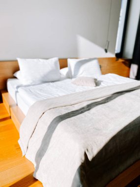 Parlak ve rahat bir yatak odası, güneşli bir dekor ve modern bir evde düzgün bir yatak.