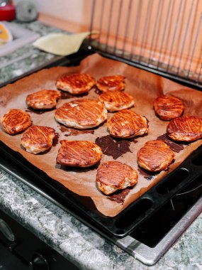 Sıcak bir mutfak ortamında, fırın tepsisinde leziz ızgara köfteler.