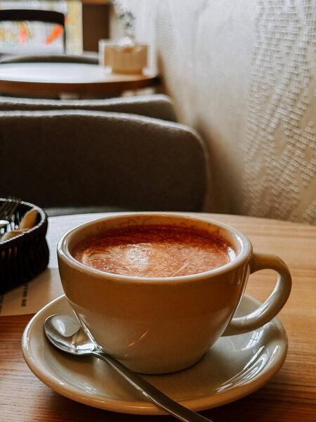 Enjoying a warm cup of coffee in a cozy cafe setting during a rainy afternoon