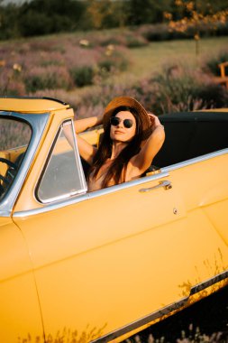 Lavanta tarlalarının ortasında güneşli bir günün tadını çıkaran bir kadın.