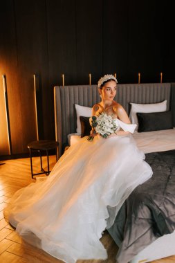 Modern bir otel odasında düğün töreninden önce bekleyen zarif bir gelin.