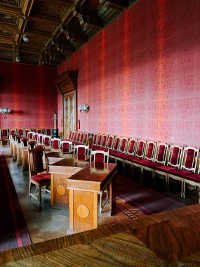 Tarihi binada uzun masalar ve sandalyelerle süslü toplantı odası.