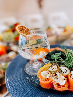 Mavi tabakta taze otlar ve narenciye ile süslenmiş lezzetli deniz ürünleri tabağı.