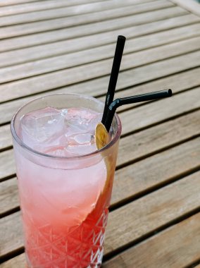 Serinletici yaz içeceği ahşap bir masada uzun bir bardakta servis edilir.