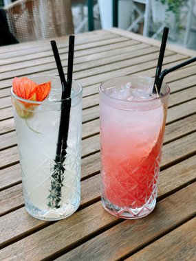 Yazın, canlı bir açık hava kafeteryasında, ahşap bir masada servis edilen canlandırıcı kokteyller.