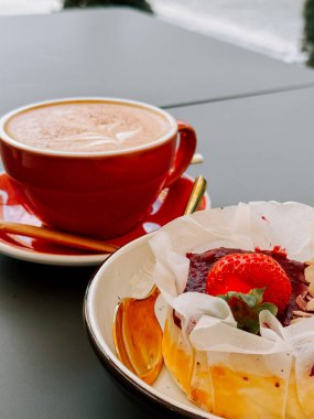 Güneşli bir öğleden sonra rıhtımda tatlı ve kahvenin tadını çıkarıyorum.