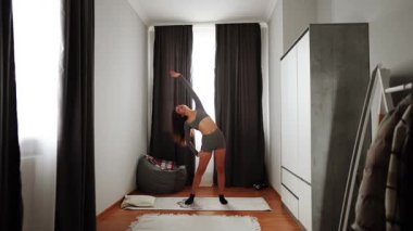 Esneklik ve rahatlama için rahat bir dairede esneme hareketleri.