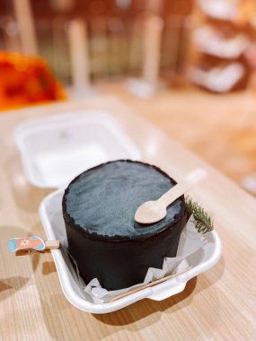 Eşsiz siyah tatlı, ahşap bir masada servis edilir.