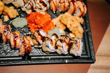 Taze suşi tabağı. Yemekte çeşitli ekmekler ve canlı garnitürlerle servis ediliyor.