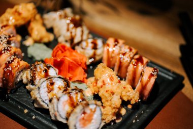 Samimi bir restoranda zencefil ve wasabi ile servis edilen lezzetli suşi tabağı.
