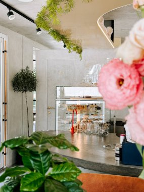 Fırında mallar ve canlı çiçek desenli modern bir kafe.
