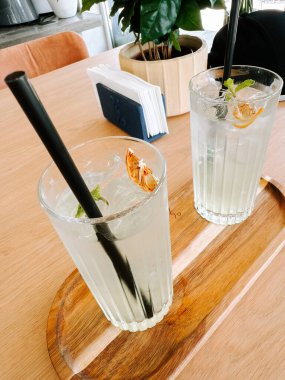 Süslü bardaklarda servis edilen naneli ve kurutulmuş portakallı içecekler.