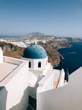 Santorini mavi kubbe ve deniz manzaralı beyaz binalar ve tepeler