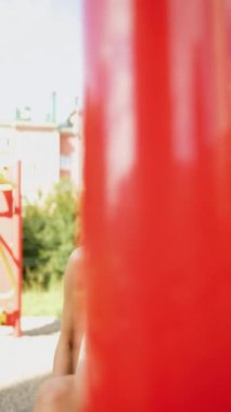 Genç bir kadın yaz günü şehir merkezinde renkli duvarların yanında güven içinde poz veriyor.