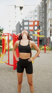 Spor meraklısı şehir parkında öğleden sonra antrenmanı sırasında güneşin altında geriliyor.