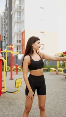 Modern bir yerleşim yerindeki spor salonunda egzersiz yapan bir kadın.