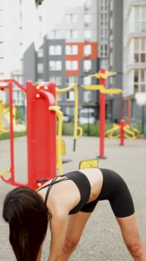 Açık hava fitness seansı modern şehir parkı ortamında güç eğitimine odaklanır.