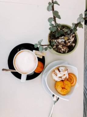 Öğleden sonra bitkilerle dolu bir kafede tatlı ve kahvenin tadını çıkarıyorum.