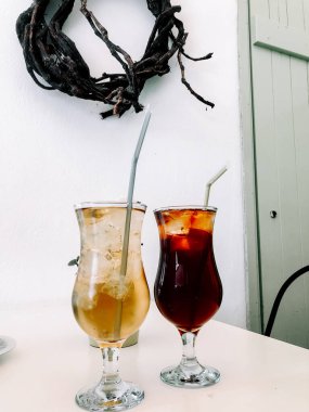 Sıcak bir kafe ortamında zarif bardaklarda servis edilen buzlu içecekler tazeleniyor.